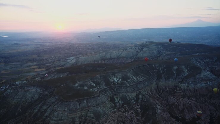 Luftfoto af varmluftballoner i Kappadokien ved solnedgang