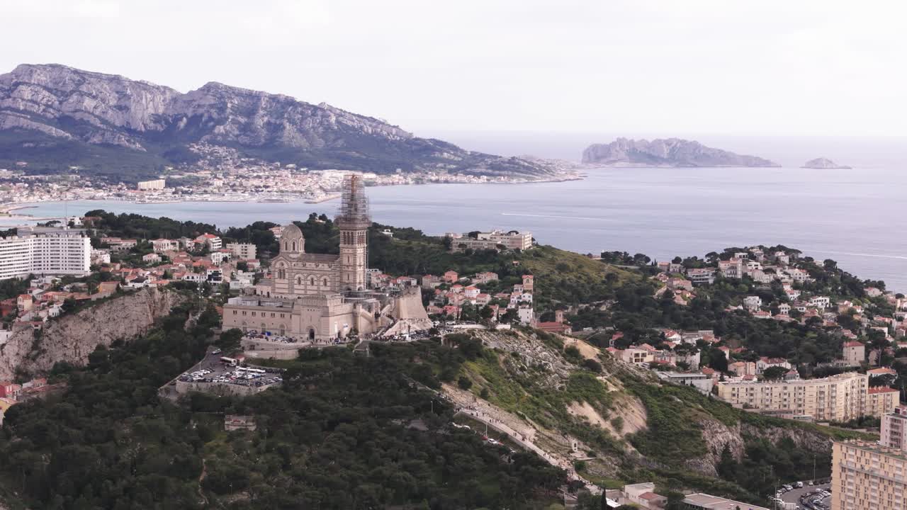 Drone spin around Notre Dame de la Garde from far, French landscape in background