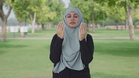 happy muslim woman reading namaz in park