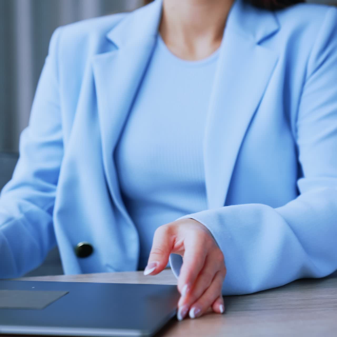 Impiegata in ufficio posa il suo quaderno e prende il portatile. Orario di lavoro in ufficio. Una collega parla al telefono sullo sfondo, in un'immagine sfocata