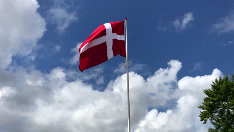 denmark flag swaying in the wind on the big pole