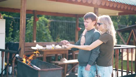 Travelling-Young-guy-with-girl-standing-near-the-barbecue