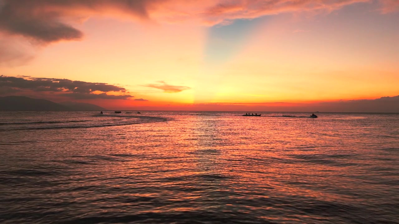 Colorful tropical sunset over calm sea with boats in Philippines