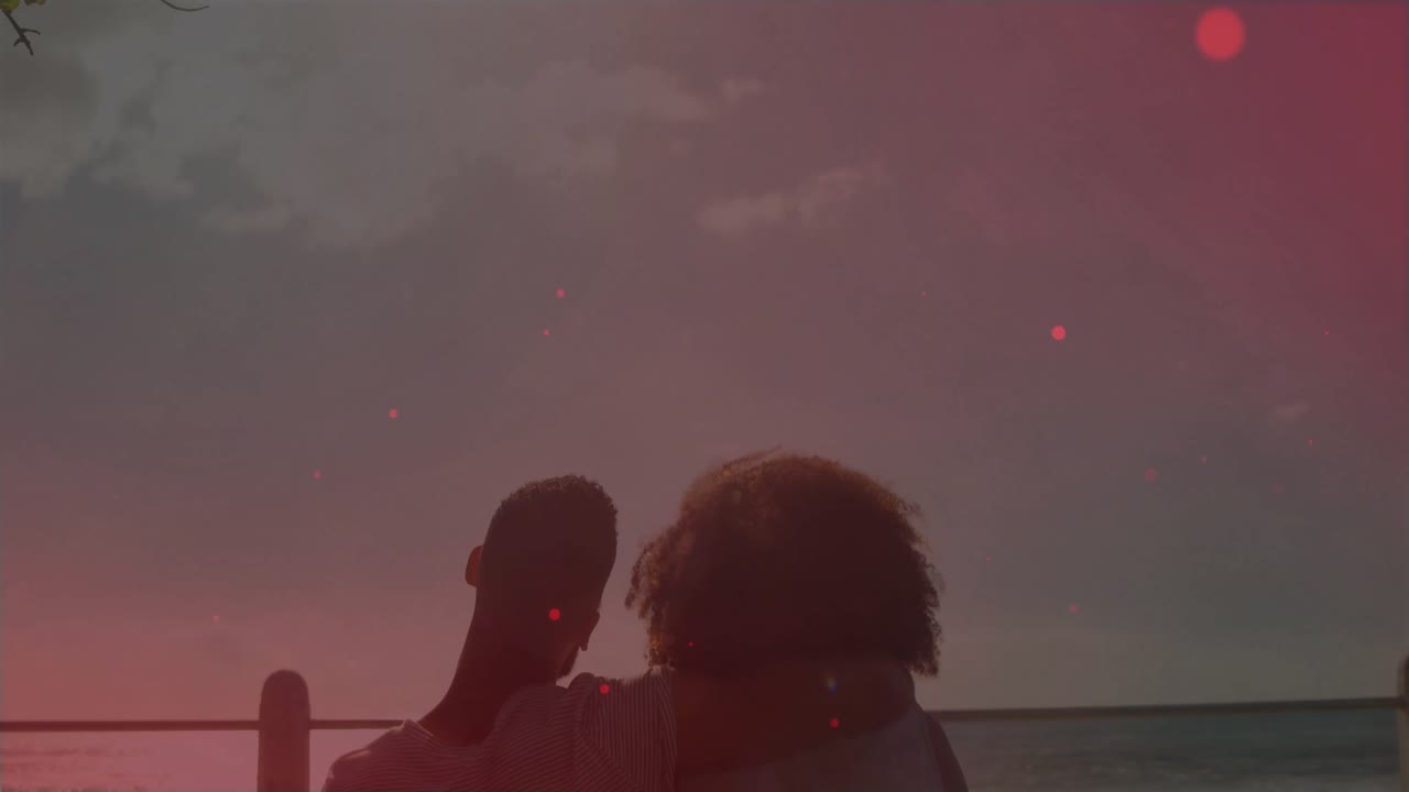 Sobreposição rosa desvanecendo, revelando um casal encostado num banco, observando o pôr do sol no horizonte do oceano, para viagem.