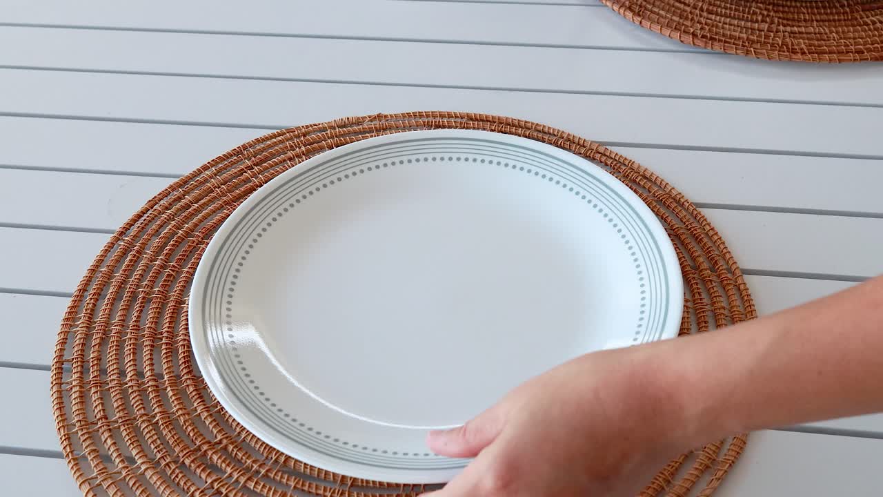 A table is set with plates and cutlery for a fried chicken meal in a bright, casual setting