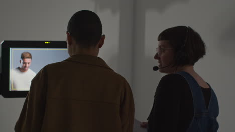 female film director and assistant watching actors shooting movie or video in studio on monitor 2