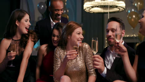 friends holding up champagne flutes together in a toast at party