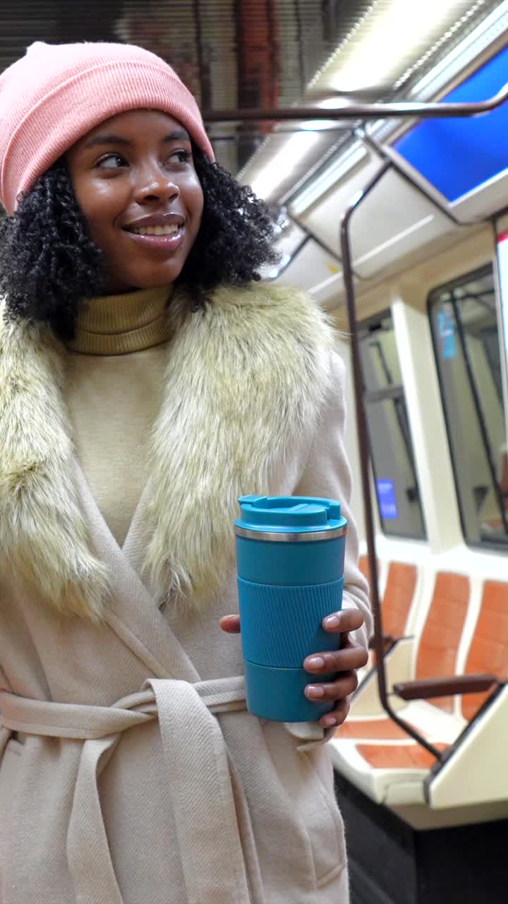 Woman in subway car with coffee cup and fur collar