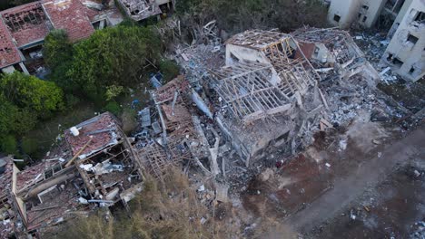 drone footage from above shows a fully collapsed residential home in northern tel aviv after a missile impact. structural remnants and rubble cover the area