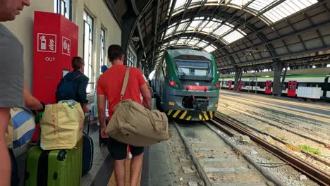 passengers prepare to board a train in milan