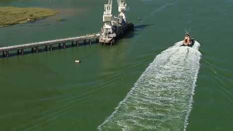 Aerial-tracking-shot-of-a-RNLI-Lifeboat-crew-sailing-down-the-Swale-Estuary-between-Kemsely-and-the-Isle-Of-Sheppey