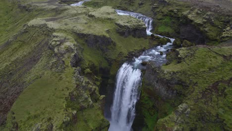 Aerial-high-above-the-famous-natural-landmark-and-tourist-attraction-of-Skogafoss-falls-and-Fimmvorduhals-trail-in-Iceland