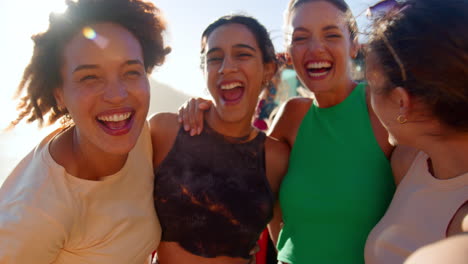 Portrait-Of-Laughing-Female-Friends-Having-Fun-Posing-For-Selfie-In-Front-Of-Car-On-Road-Trip