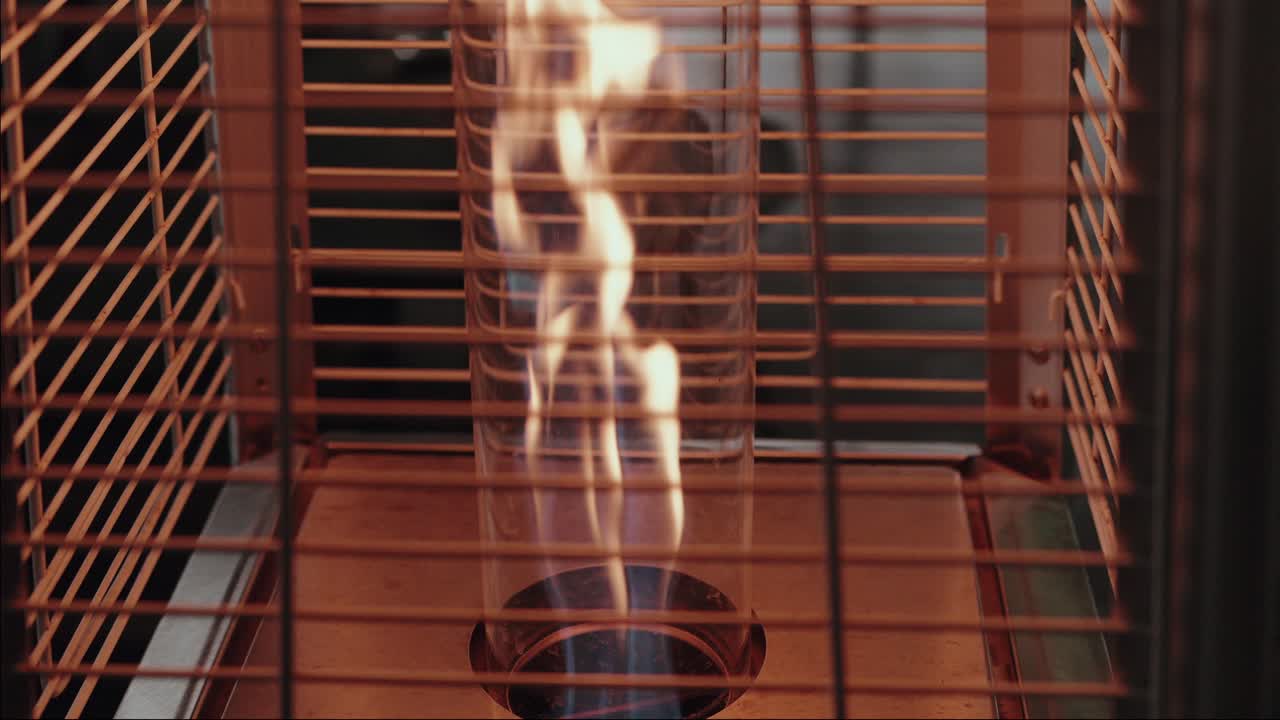 Close up of active gas heater flame inside protective metal grid
