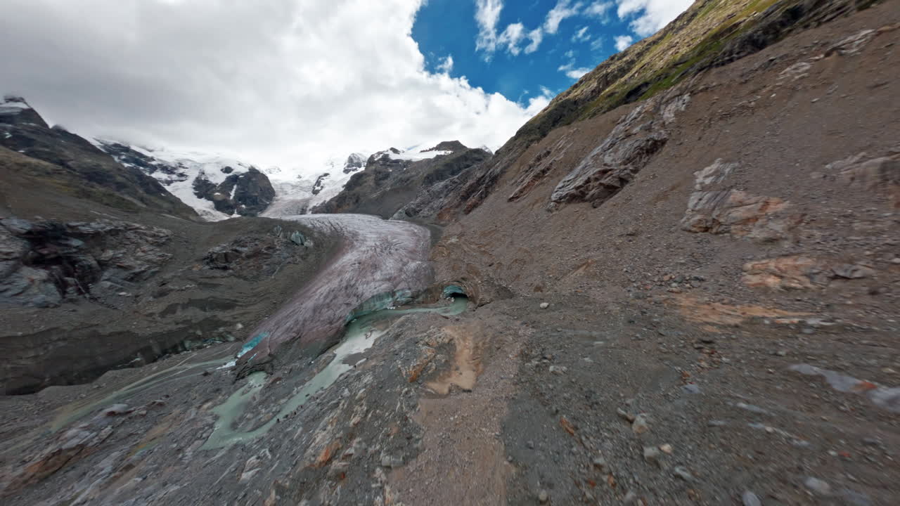 Dramatic Morteratsch Glacier scene with rocky terrain under blue sky