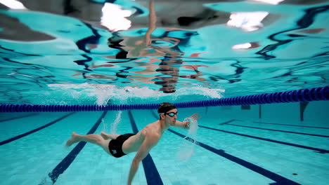 hombre nadando bajo el agua en una piscina