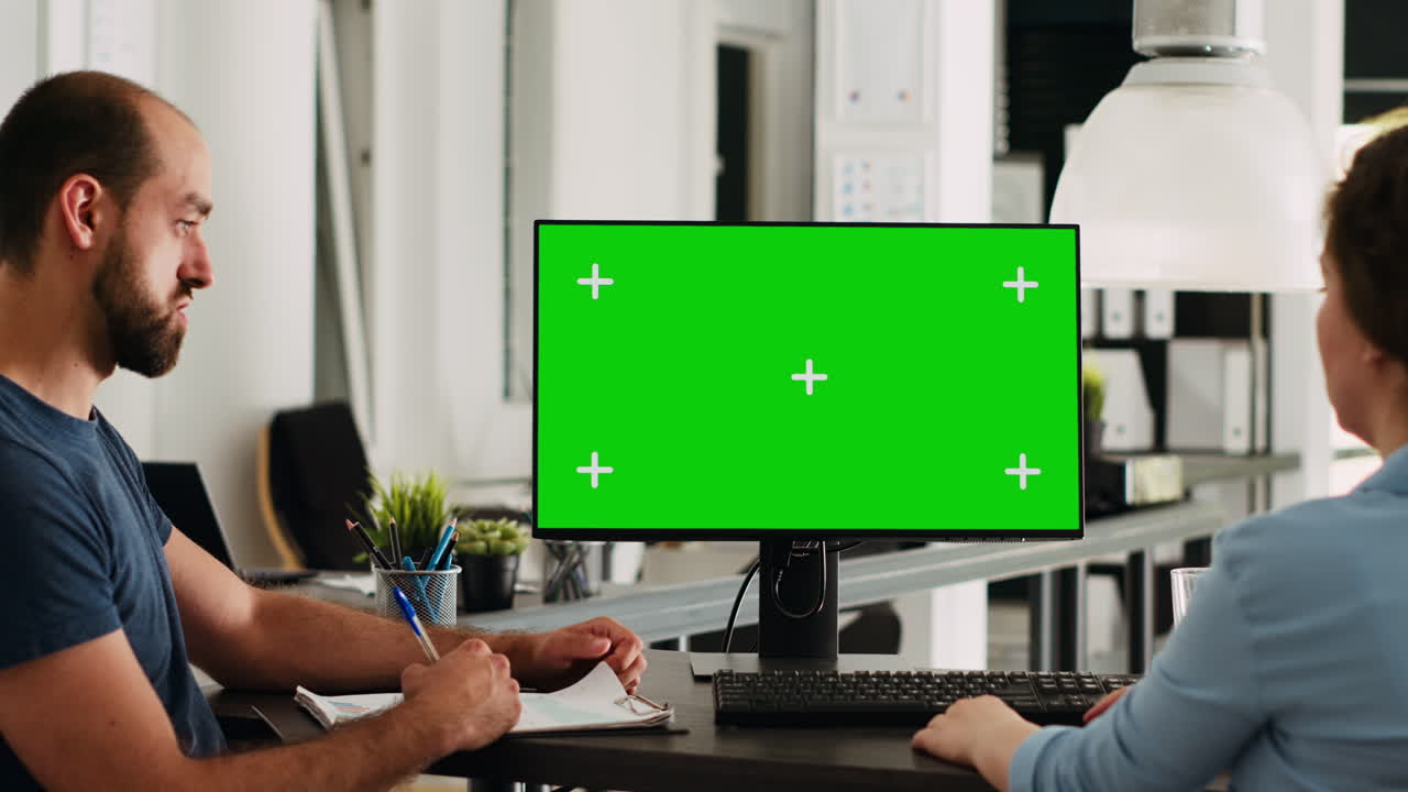 Coworkers using pc with greenscreen