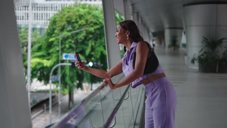 woman taking selfie on city bridge