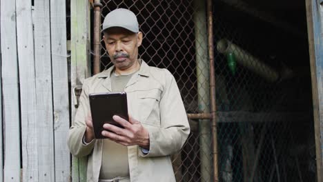 African-american-male-gardener-using-tablet-at-garden-center