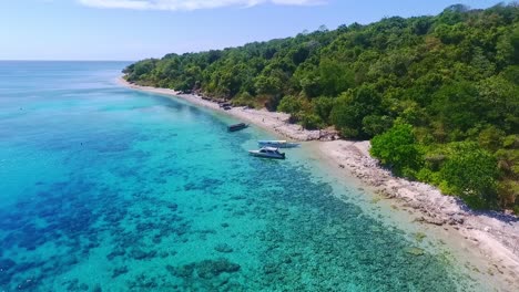 aerial pull out shot over beautiful crystal clear beaches of moyo island in indonesia