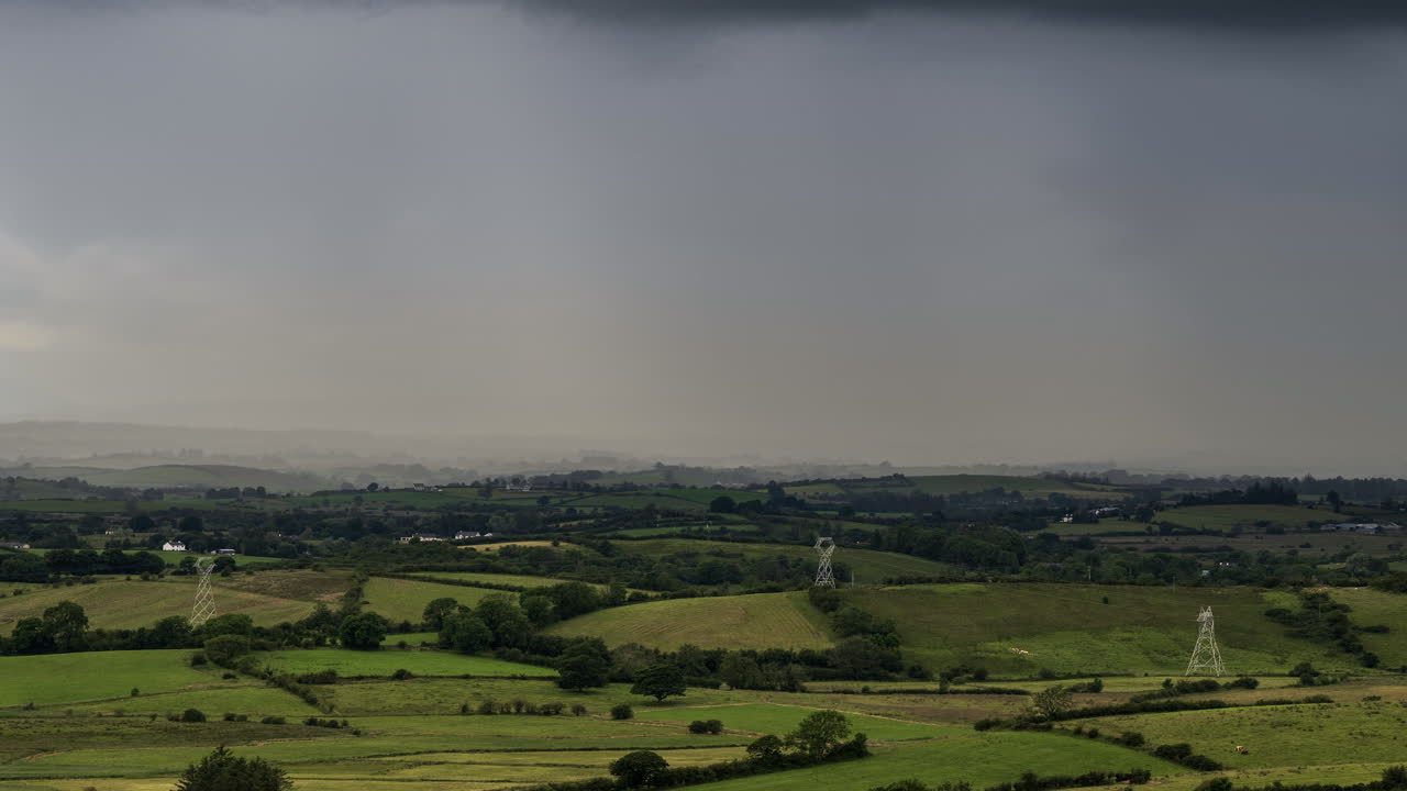 아일랜드에서 폭풍우가 몰아치는 날 동안 풀밭과 언덕이 있는 시골 농업 풍경의 시간 경과