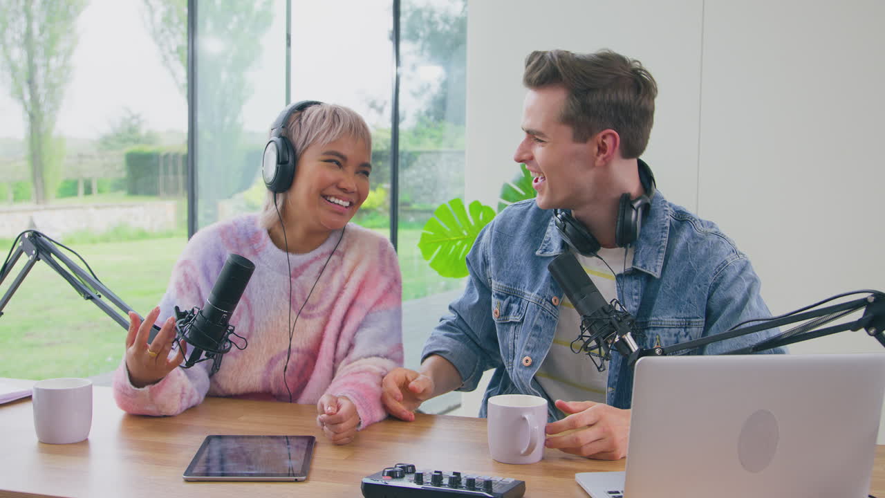retrato de una pareja con auriculares haciendo vlog con micrófono en transmisión en vivo