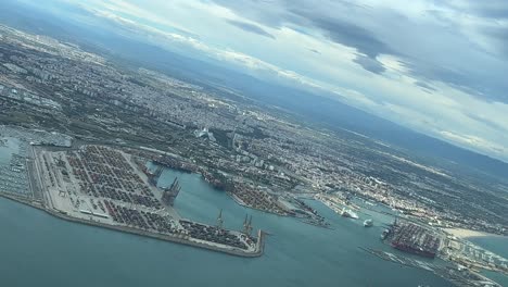 Aerial-view-of-Valancia-city-and-harbor,-Spain,-shot-from-a-jet-cabin-approaching-to-the-airport
