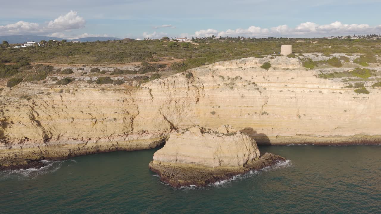 Ripresa aerea che ruota attorno a Torre da Lapa mentre rivela spettacolari formazioni rocciose lungo la costa meridionale portoghese