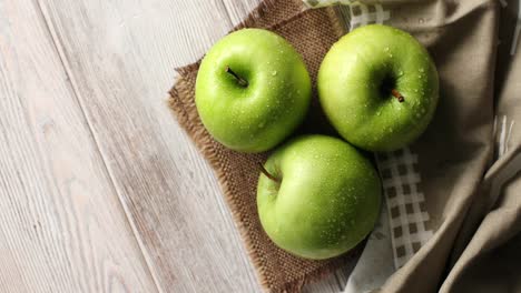 wet green apples on canvas