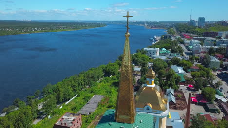 aerial view of a city with a church by a river