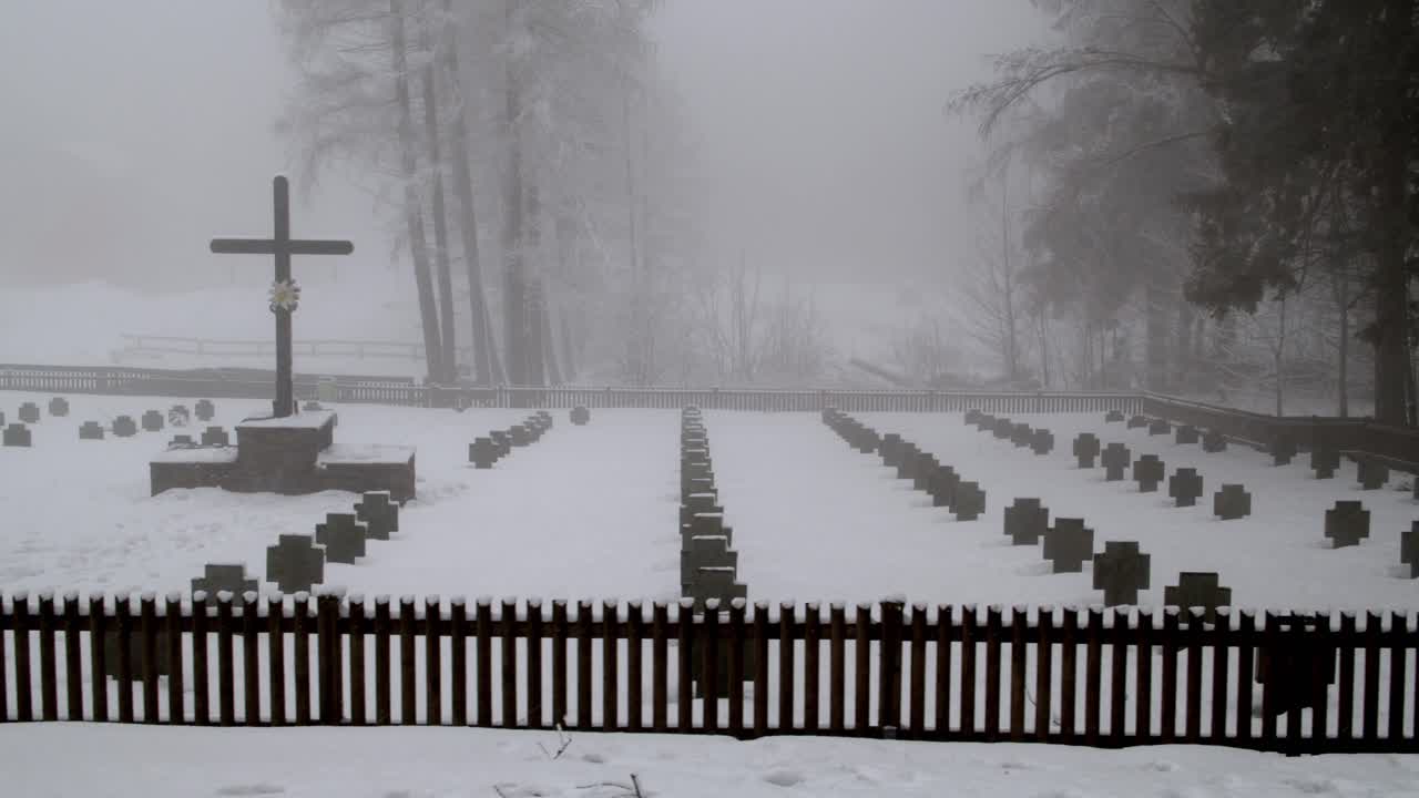 겨울에 배경에 안개 낀 숲이 있는 눈 덮인 군인의 전쟁 무덤