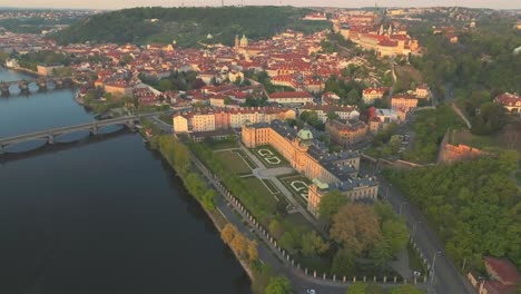 Praga,-República-Checa---Zahrada-Strakovy-Akademie-Y-El-Castillo-De-Praga,-Puente-De-Carlos,-Que-Cruza-El-Río-Vltava---Toma-Aérea-De-Drones