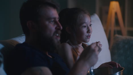 father and daughter watching a movie