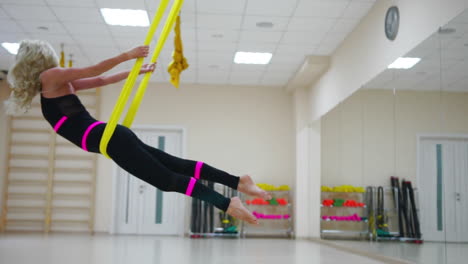 fly yoga in a white gym. gymnastics performs physical exercises for fly yoga, pilates, restorative health