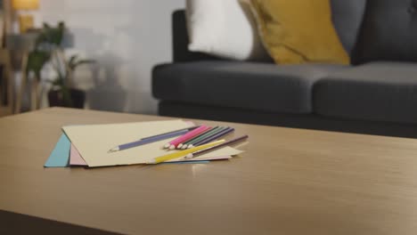 lápices de color y papel en la mesa en casa para el niño diagnosticado con tea