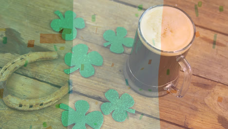 digital composite of mug of beer, shamrock & horseshoe for st patricks day on wooden table