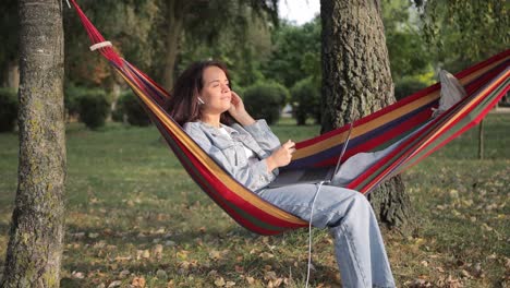 woman relaxing in a hammock with a laptop