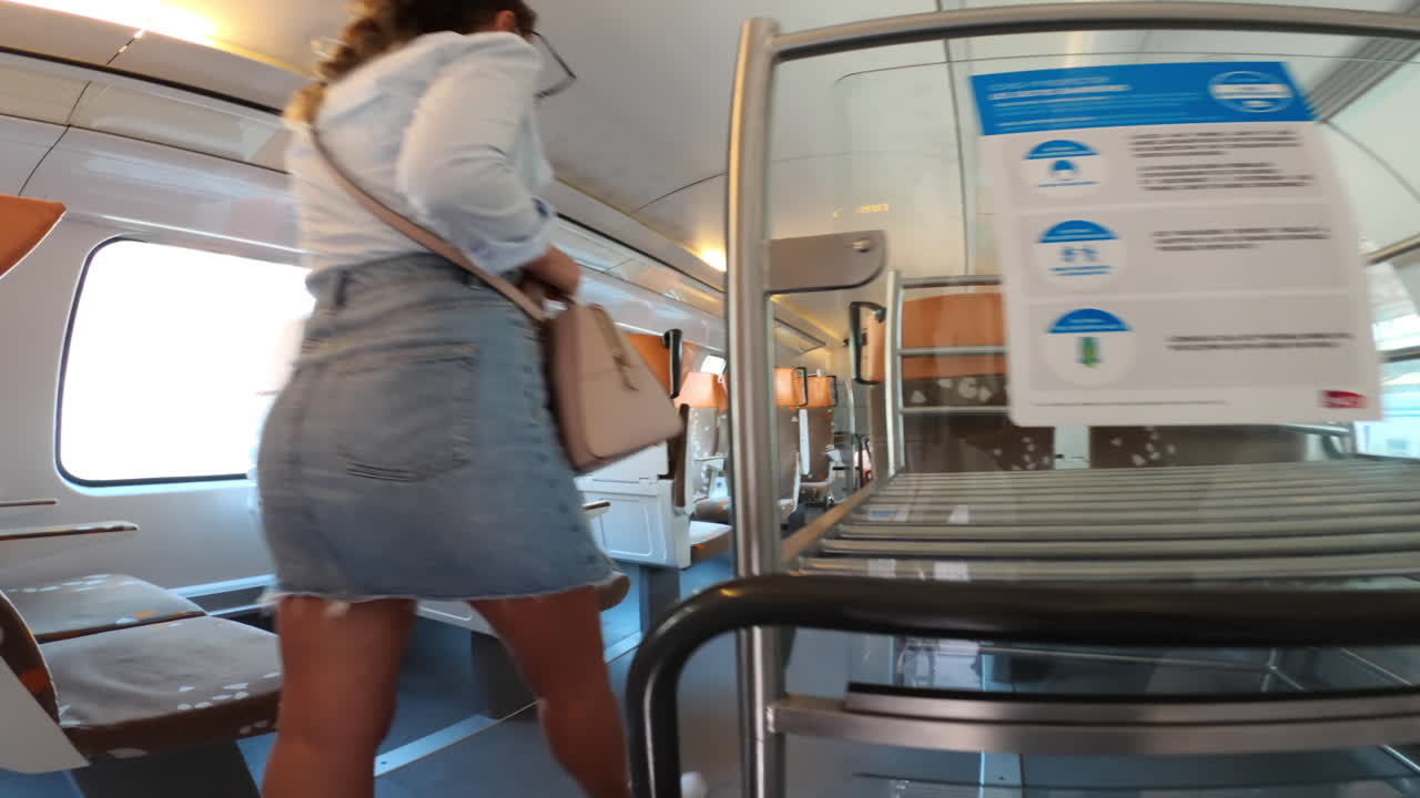 Woman entering an empty train at the station and finding a seat