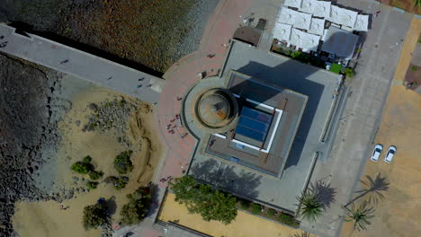 rotating aerial view of a tall tower near the beach. bird view of a lighthouse near the beach. 4k footage tropical view