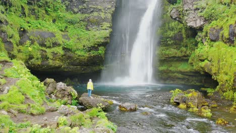 woman in front of a big waterfall in iceland