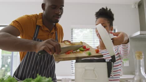 video of happy african american couple cooking together in kitchen