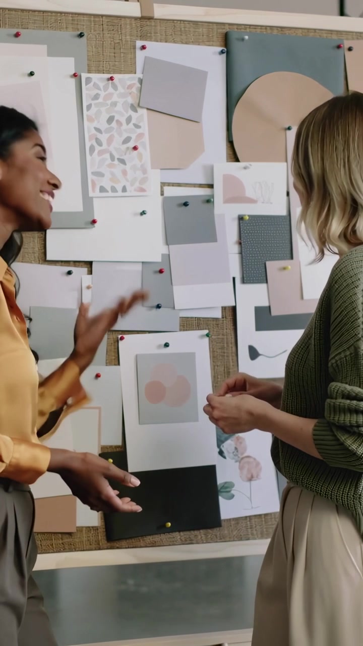 Vertical video: Pointing left woman leading peer fixing pinboard cards studio choosing hue mustard