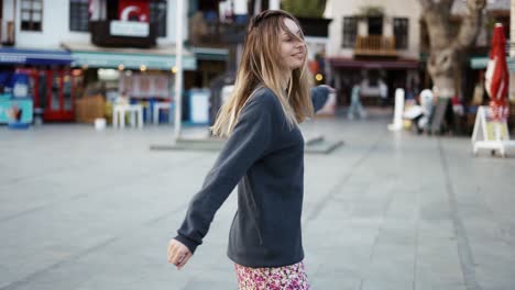 blonde woman dance outdoors, turn around to express positive emotions