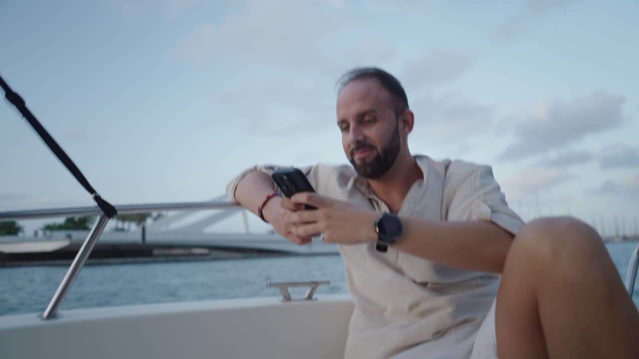 Uomo su una barca che guarda il suo smartphone