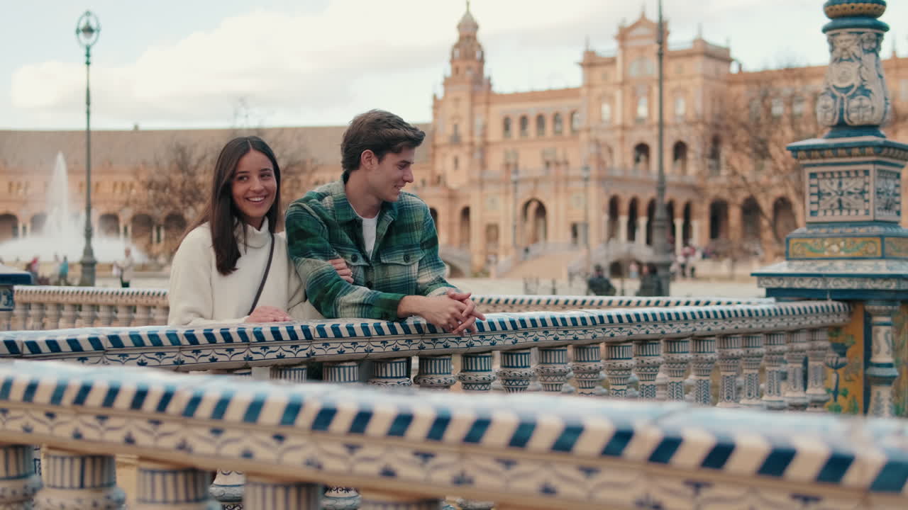 Jovem casal feliz, homem e mulher conversando em pé em uma cidade europeia antiga