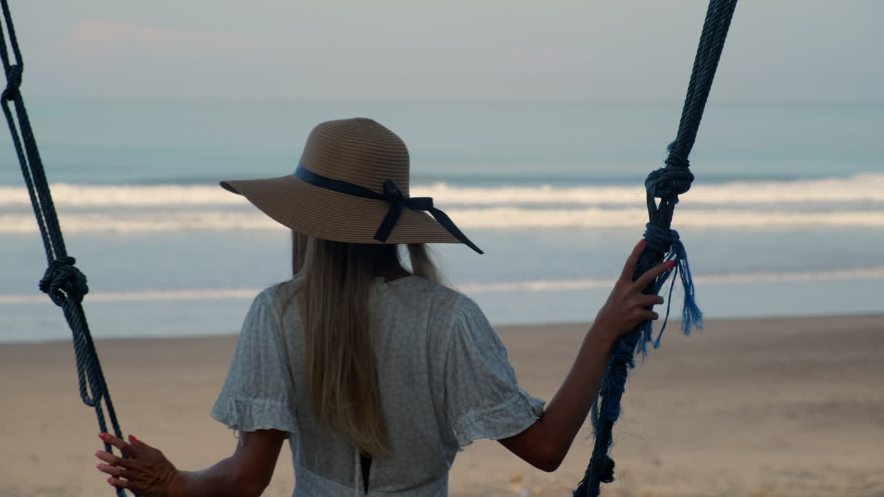 женщина на качелях на пляже