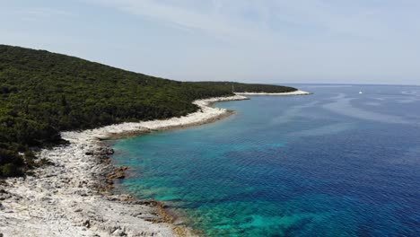 white stone beach in the coast of emplisi beach in kefalonia, greece - aerial shot