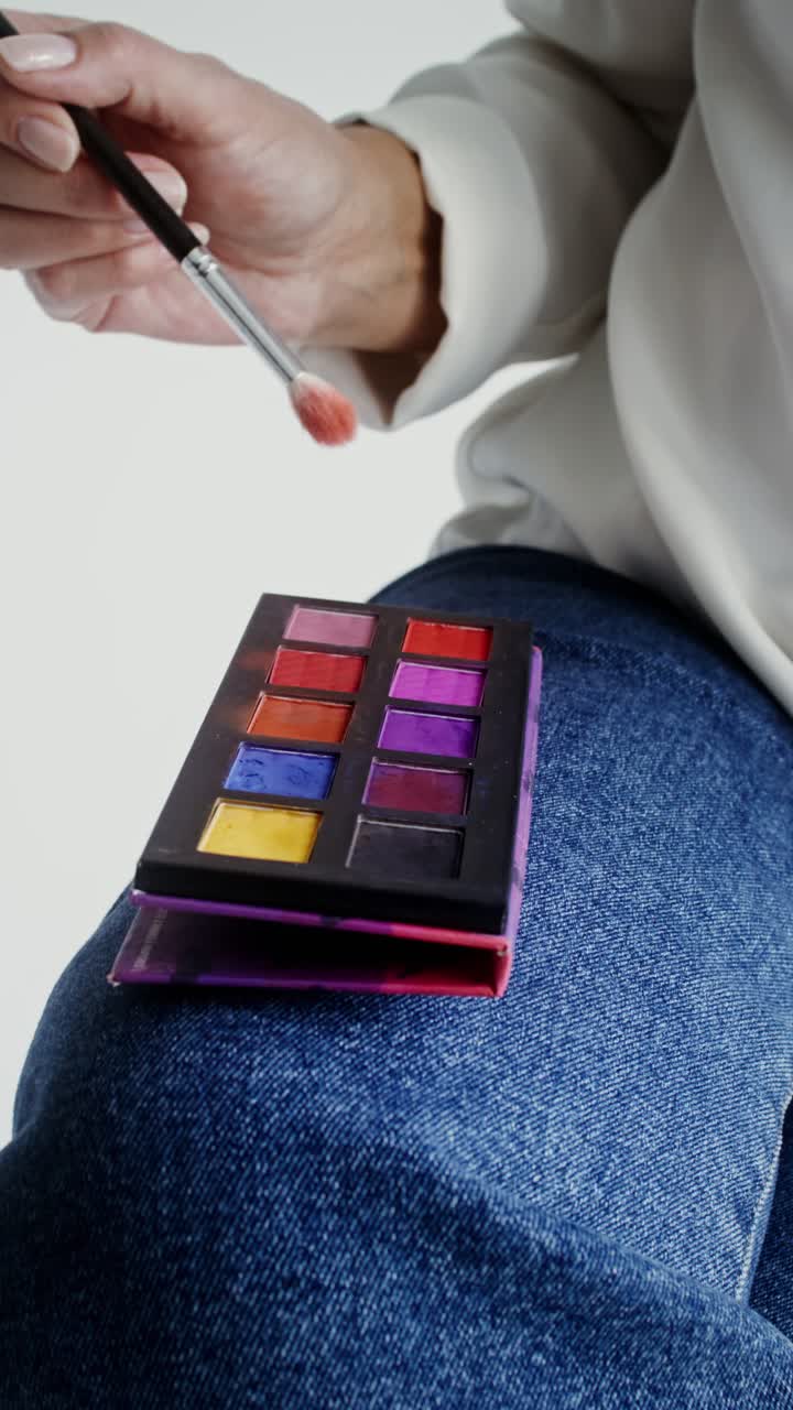Makeup palette on lap with brush