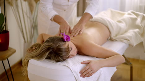 mujer recibiendo un masaje relajante en la espalda en un spa