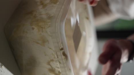 cerrando un recipiente de plástico con masa para dejar reposar y leudar